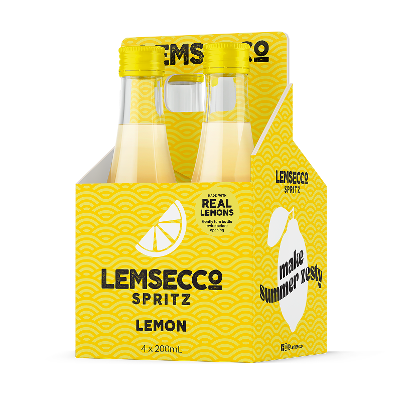 Four bottles of Lemsecco Lemon Prosecco Spritz Minis in a bright yellow carrier with wave patterns, a lemon slice image, and text promoting “make summer zesty” and “made with real lemons.”.