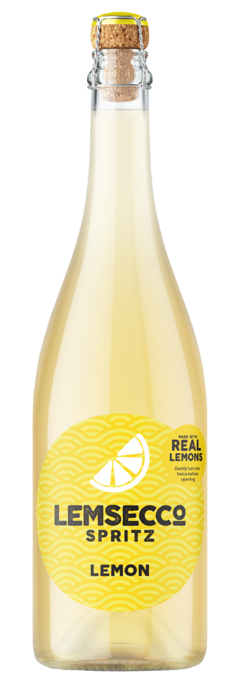 A clear glass bottle of Lemsecco Lemon Prosecco Spritz features a yellow label with a lemon slice graphic and “Made with real lemons” at the bottom. The refreshing blend inside is sealed with a cork and wire closure.